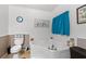 Clean bathroom showcasing a soaking tub, wainscotting, toilet, and brown accent rugs at 7012 Walden Ct., Myrtle Beach, SC 29588