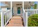 Inviting covered front porch with brick steps and seating area and Welcome sign at 7012 Walden Ct., Myrtle Beach, SC 29588