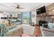 Inviting living room with a brick fireplace, large windows, and a ceiling fan at 7012 Walden Ct., Myrtle Beach, SC 29588