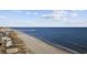 Stunning coastal aerial featuring a sandy beach alongside the blue ocean with a pier in the distance at 712 Dogwood Dr. S # 101, Surfside Beach, SC 29575