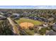Aerial view of a park with a baseball field and peaceful pond surrounded by lush trees at 712 Dogwood Dr. S # 101, Surfside Beach, SC 29575