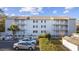 Three-story condo with a light gray exterior, black shutters, and white balconies surrounded by a well maintained landscape at 712 Dogwood Dr. S # 101, Surfside Beach, SC 29575
