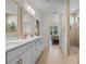 Bright bathroom featuring double vanity, linen cabinet, tiled floor, and walk-in shower with glass surround at 1421 Crested Iris Way, North Myrtle Beach, SC 29582