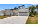 A view of the three-car garage with a concrete driveway at 1421 Crested Iris Way, North Myrtle Beach, SC 29582