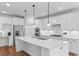 Bright kitchen featuring a large island with bar seating, stainless steel appliances and hardwood floors at 1421 Crested Iris Way, North Myrtle Beach, SC 29582