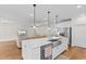 Open-concept kitchen with a large island, stainless steel appliances, and hardwood flooring at 1421 Crested Iris Way, North Myrtle Beach, SC 29582
