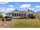 Spacious backyard with a well-maintained lawn, red shuttered house, and inviting patio area at 761 Drawbridge Dr., Conway, SC 29526