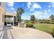 Beautiful backyard featuring a stone patio, outdoor kitchen, lush greenery, and a picturesque view of the lake at 8050 Wacobee Dr., Myrtle Beach, SC 29579