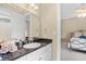 Elegant bathroom vanity with granite countertop, white cabinetry, decorative mirror and sink with view to an adjacent bedroom at 8050 Wacobee Dr., Myrtle Beach, SC 29579
