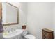 Powder room with pedestal sink, decorative mirror, and woven storage cabinet at 8050 Wacobee Dr., Myrtle Beach, SC 29579