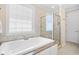 Main bathroom featuring a soaking tub, glass shower, and tile surround at 8050 Wacobee Dr., Myrtle Beach, SC 29579