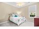 Inviting bedroom with metal-framed bed, ceiling fan, plush carpet, and natural light from a window offering outdoor views at 8050 Wacobee Dr., Myrtle Beach, SC 29579