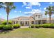 Beautiful home exterior with manicured lawn, mature trees, and a spacious patio with an upper-level balcony at 8050 Wacobee Dr., Myrtle Beach, SC 29579