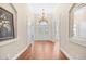 Bright foyer with hardwood floors, chandelier, and arched doorway creates a grand entrance at 8050 Wacobee Dr., Myrtle Beach, SC 29579