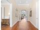 Spacious hallway with hardwood floors and arched doorway leading to a sunlit living area at 8050 Wacobee Dr., Myrtle Beach, SC 29579