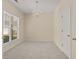 Cozy bedroom featuring neutral decor, a chandelier, natural lighting from a large window, and neutral carpet at 832 Pembridge Ct., Myrtle Beach, SC 29579