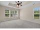 Spacious bedroom featuring tray ceiling, ceiling fan, and multiple windows at 832 Pembridge Ct., Myrtle Beach, SC 29579