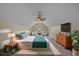 This staged bedroom features a ceiling fan, tv, and chairs by the window for a relaxing setup at 832 Pembridge Ct., Myrtle Beach, SC 29579