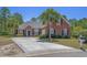 Charming red brick home featuring a well-manicured lawn, palm trees, and a spacious concrete driveway at 832 Pembridge Ct., Myrtle Beach, SC 29579