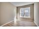 A bright bedroom features neutral walls and wood-look flooring with a large window at 912 Inlet Keys St., Murrells Inlet, SC 29576