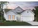 Charming, light gray two-story home featuring an attached two-car garage, manicured lawn, and well-maintained landscaping at 912 Inlet Keys St., Murrells Inlet, SC 29576