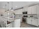 Modern kitchen boasts white cabinets, stainless steel appliances, granite countertops, and a breakfast bar with seating at 912 Inlet Keys St., Murrells Inlet, SC 29576