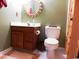 Bathroom with a wooden vanity, decorative mirror, toilet, and tiled floor at 916 Charles St., North Myrtle Beach, SC 29582