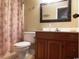 Cozy bathroom with wooden vanity, neutral tiling and a floral curtain at 916 Charles St., North Myrtle Beach, SC 29582