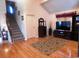 Bright living room with hardwood floors, staircase, large TV, and neutral decor at 916 Charles St., North Myrtle Beach, SC 29582