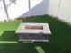Outdoor fire pit set on artificial turf, enclosed by a white privacy fence, perfect for evening gatherings at 928 Strand Ave. Strand Ave., North Myrtle Beach, SC 29582
