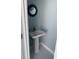 A view of a powder room with a pedestal sink, round decorative mirror and soothing blue wall color at 928 Strand Ave. Strand Ave., North Myrtle Beach, SC 29582