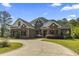 Stunning two-story brick home features a circular driveway, beautiful landscaping, and mature trees at 9449 Freewoods Rd., Myrtle Beach, SC 29588