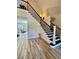 Inviting foyer features a staircase with wrought iron railing and wood-look tile flooring at 9449 Freewoods Rd., Myrtle Beach, SC 29588