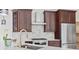 Modern kitchen with marble backsplash, stainless steel appliances, and rich wood cabinetry at 9449 Freewoods Rd., Myrtle Beach, SC 29588