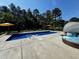 Inviting pool with jacuzzi, lounge seating, and colorful umbrellas surrounded by lush greenery at 9449 Freewoods Rd., Myrtle Beach, SC 29588