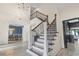 Elegant staircase with dark wood and wrought iron detailing in a light-filled foyer at 9449 Freewoods Rd., Myrtle Beach, SC 29588