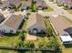 Aerial view of a home with a brick patio, lush green yard, mature trees, and fence at 962 Witherbee Way, Little River, SC 29566