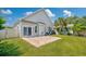 This beautiful home has a well-manicured backyard with a brick patio, lush grass, and mature trees at 962 Witherbee Way, Little River, SC 29566