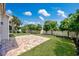 Backyard featuring a brick patio, green lawn, trees and a white fence at 962 Witherbee Way, Little River, SC 29566