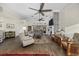 Bright living room featuring a decorative fireplace, ceiling fans, and large windows, creating a warm and inviting atmosphere at 9628 Indigo Creek Blvd., Murrells Inlet, SC 29576
