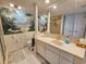 Well-lit bathroom with palm tree wall art, a marble countertop, and white cabinets at 9650 Shore Dr. # 2007, Myrtle Beach, SC 29572