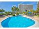 A spacious pool with multiple deck chairs and tropical landscaping offers a relaxing atmosphere at 9994 Beach Club Dr. # 2403, Myrtle Beach, SC 29572