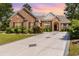 Charming brick home with lush landscaping, black shutter accents, and a wide concrete driveway at 1004 Addington Ct., Murrells Inlet, SC 29576