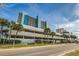 Beautiful resort building with covered parking and tropical palm tree landscaping at 1012 N Waccamaw Dr. # 301, Garden City Beach, SC 29576