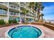 Enjoy this inviting hot tub with brick trim, set against the backdrop of a resort building and ocean at 1012 N Waccamaw Dr. # 301, Garden City Beach, SC 29576