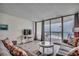 Relaxing living area with ocean view balcony access, television and comfortable seating at 1012 N Waccamaw Dr. # 301, Garden City Beach, SC 29576
