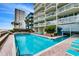 Large pool area with ocean view and plentiful lounge chairs, perfect for relaxation and enjoyment at 1012 N Waccamaw Dr. # 301, Garden City Beach, SC 29576