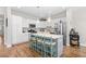 Bright, all-white kitchen featuring quartz countertops, large island with seating, and stainless-steel appliances at 1048 Longwood Bluffs Circle, Murrells Inlet, SC 29576