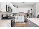Bright kitchen with stainless steel appliances, quartz countertops and white cabinets and stylish details at 1048 Longwood Bluffs Circle, Murrells Inlet, SC 29576