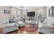 Cozy living room featuring bright windows, hardwood floors, and comfortable seating arrangement at 1048 Longwood Bluffs Circle, Murrells Inlet, SC 29576